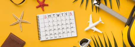 Afbeelding van een kalender met daarnaast een koffer en een paspoort